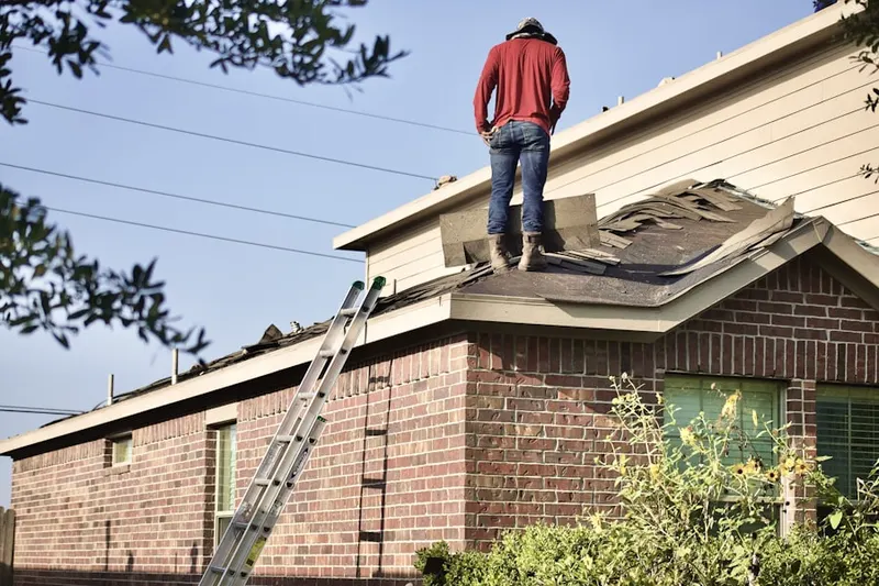 Professional roofer working on a residential roof in Air City